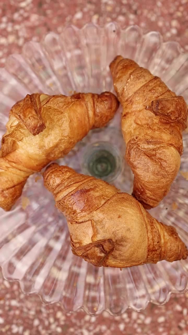 Three Golden Brown Croissants on a Clear Glass Plate