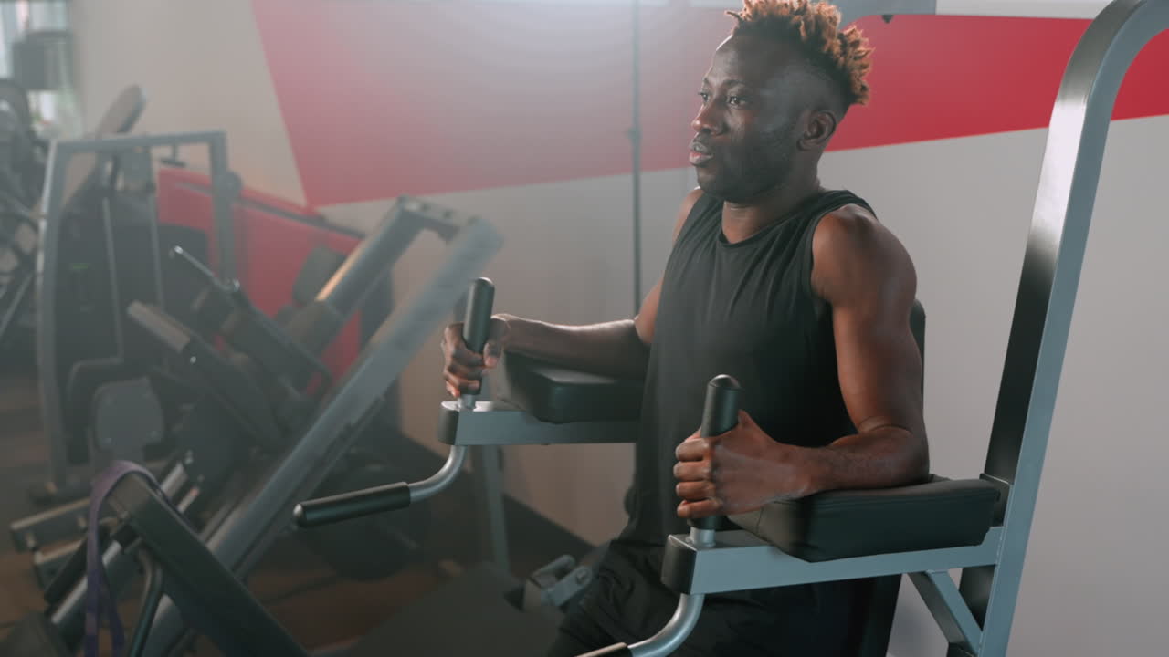 Man working out on a sit-up machine in a gym