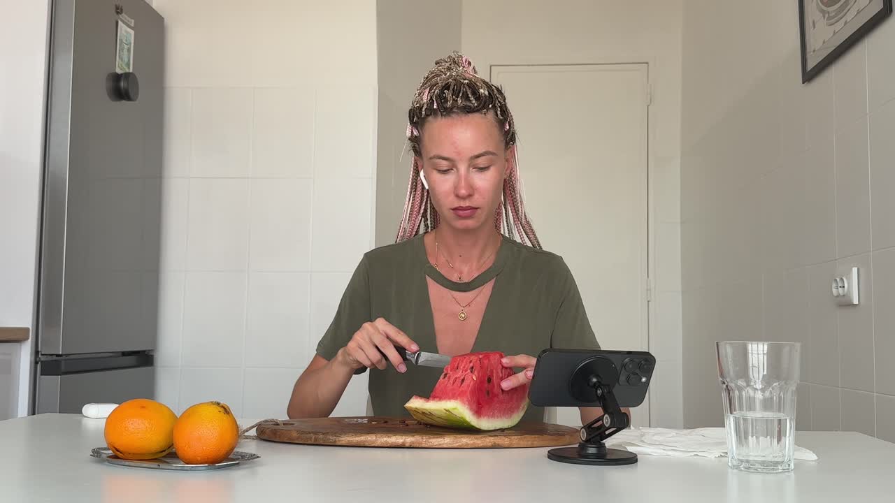 Woman Cutting and Eating Fresh Watermelon in a Bright Kitchen