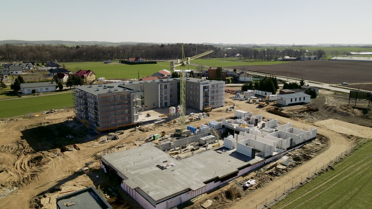 construcción en progreso de un edificio de pisos en lubawa polonia durante el día - movimiento de retroceso lento del dron aéreo