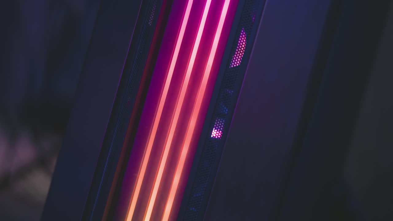 Close up of speaker system with glowing multicolored circular lights creating radiant tech atmosphere, showcasing vivid RGB hues in modern dark studio setup with soft reflections
