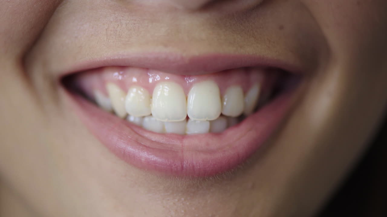 cerca de los labios de la mujer joven sonriendo mostrando dientes blancos sanos concepto de salud dental
