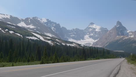 rv caravan driving in banff national park with rocky mountains in canada