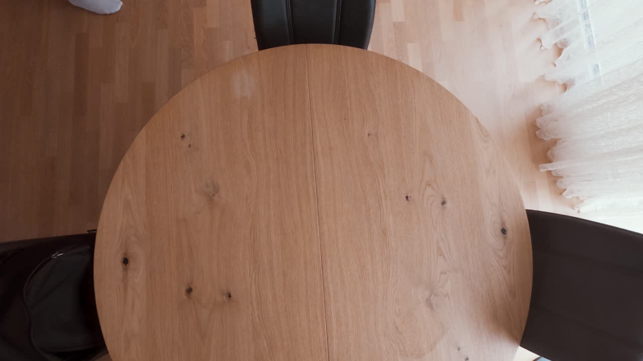 A man enters the room and places a red folder with documents on a wooden table, preparing for a lease or house purchase. Perfect for real estate, rent, mortgage, or property deal visuals