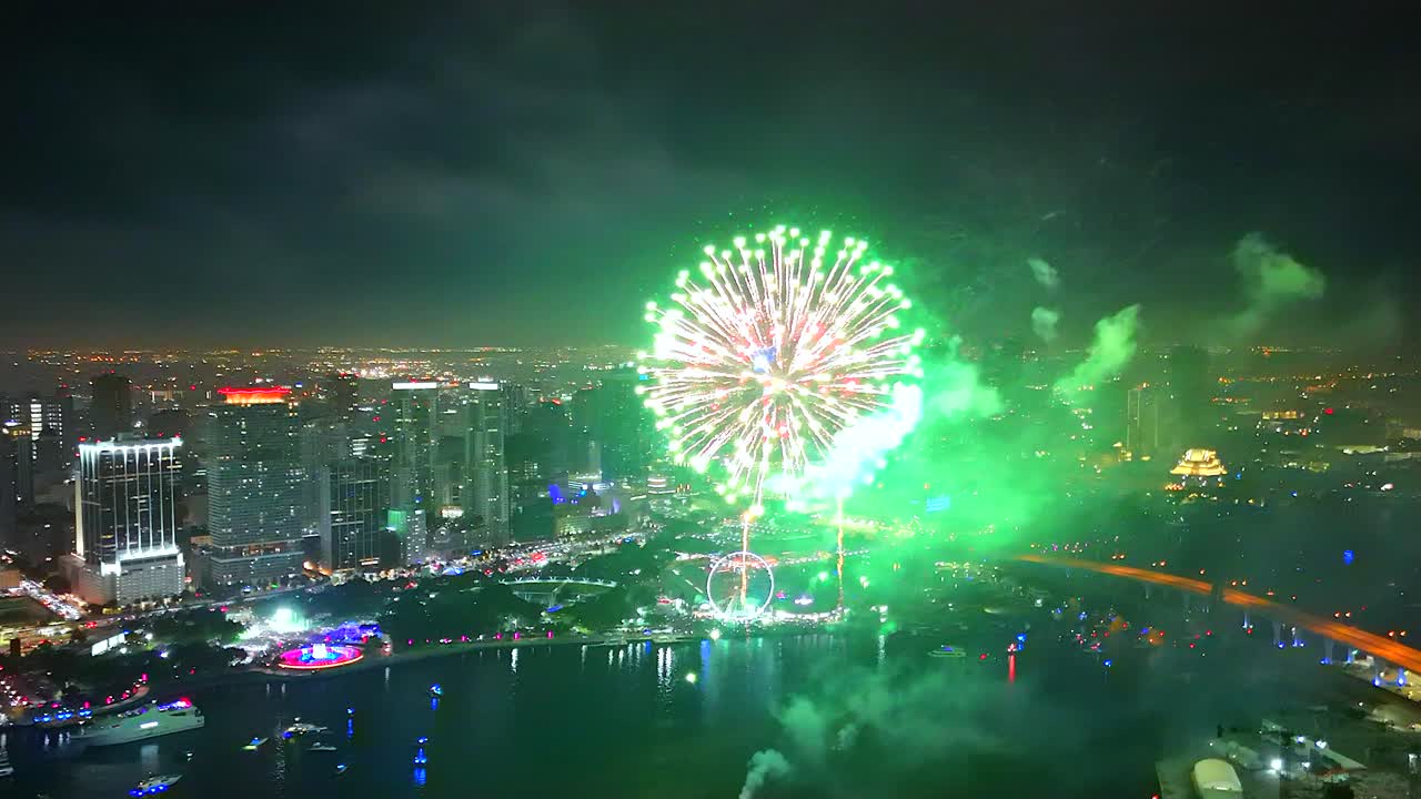 Explosive bursts captured in sweeping detail as fireworks arc and bloom over the bay from a high-flying drone perspective