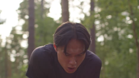 close up of tired mid adult man exercising doing work out outdoors running along track through forest stopping to catch breath shot in real time 2