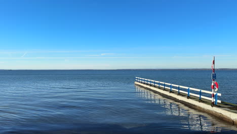 boardwalk on empty beach near calm ocean