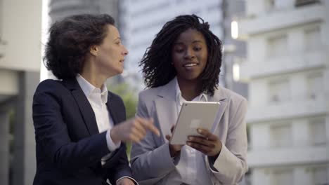 mujeres de negocios emocionales con tablet pc al aire libre