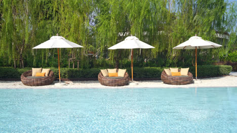 umbrella with bed pool around swimming pool with ocean sea background - holiday and vacation concept