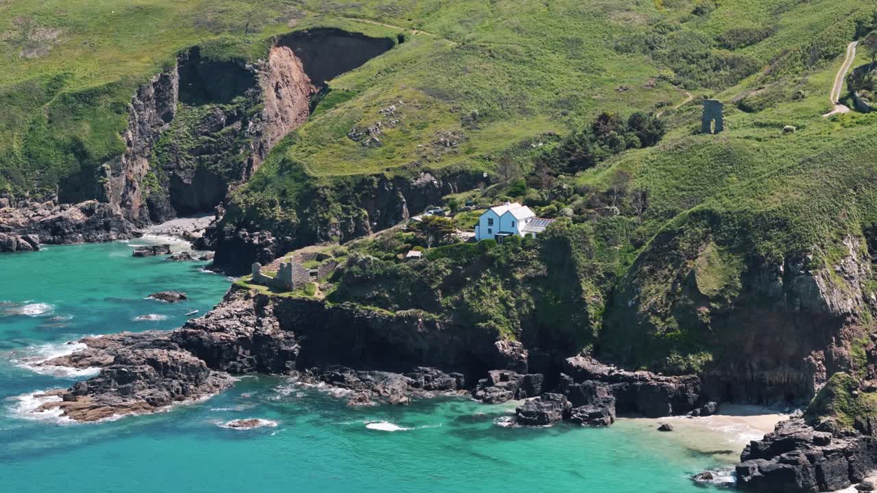 Drone flyover of coastal ruins on cliffs of Cornwall, showing history and sea below