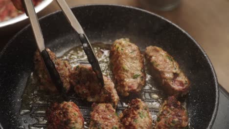 Unrecognizable-cook-turning-Salisbury-steaks-on-pan