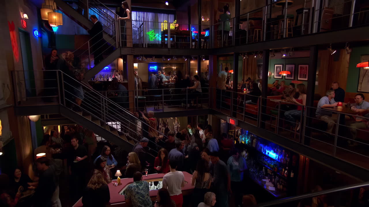 People enjoying drinks and socializing in a bustling multi-level bar