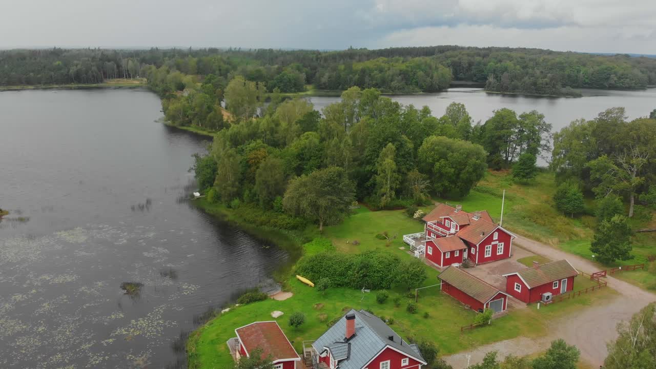 Pemandangan udara rumah kayu merah klasik di samping danau dan hutan di Ljungby Swedia