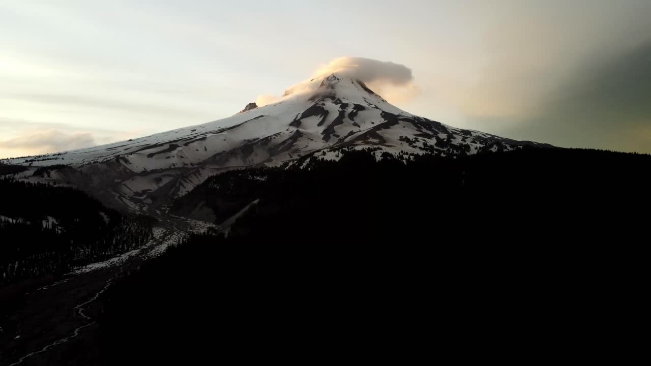 US, Oregon, Mt Hood, , 2025-05-10 - Drone view of Mt Hood in northern Oregon at sunset with clouds curling over the peak of the mountain in the Spring.