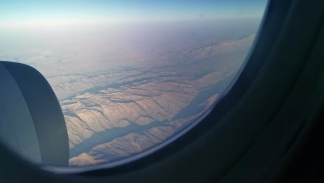 aerial view from the window seat of a passenger plane onto the rugged mountains of remote iran