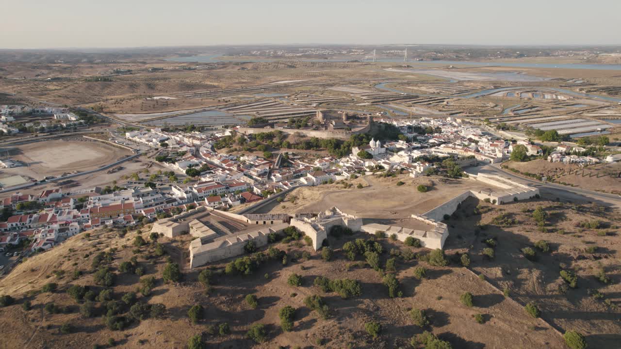 tiro ascendente de la fortaleza y el castillo históricos en castro marim con una gran extensión de salinas y el río guadiana