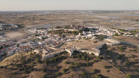 ascending shot of historical fort and castle in castro marim with vast expanse of salt pans and guadiana river