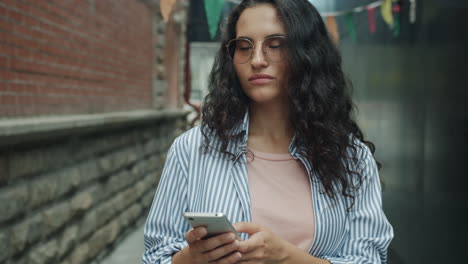 woman texting on smartphone in urban alley