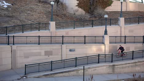 slow motion aerial footage of biker riding on an urban trail