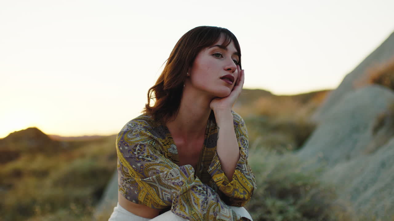 una mujer se sienta cerca de las rocas.