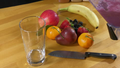 pouring fruit smoothie into glass from blender