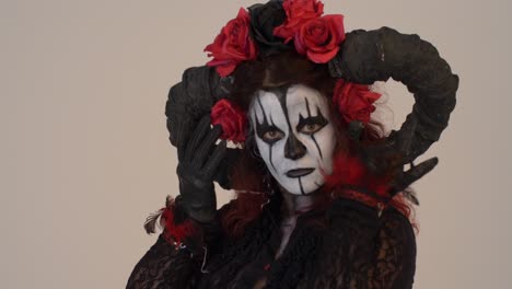 catrina cosplay girl moving her hands infront of her face and angelical eyes with a light background, medium close up