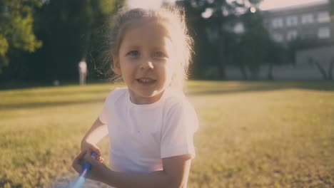 cute girl runs along lawn catching butterflies on sunny day 1