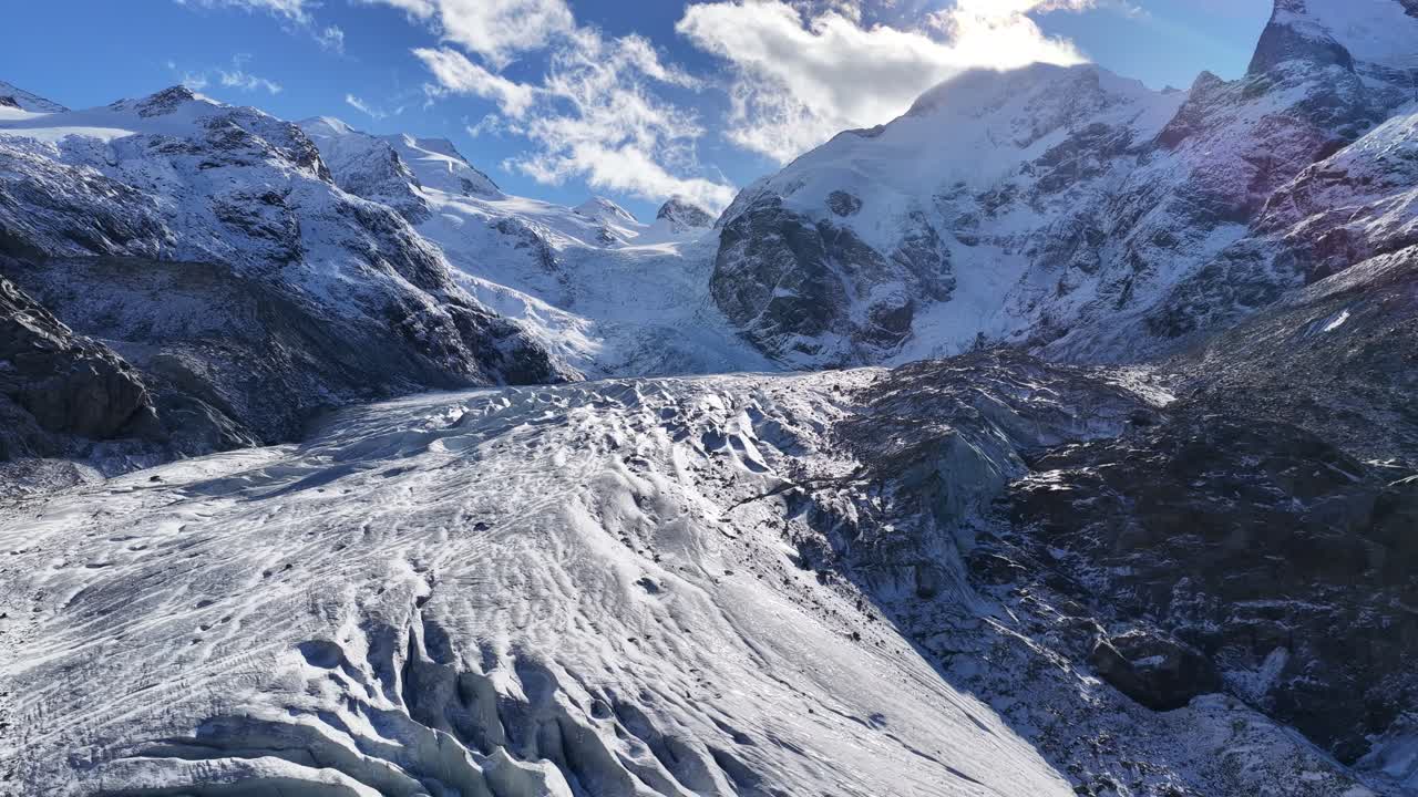 Engadin valley near St Moritz Switzerland with snow covered mountains and glacier, drone pulls back
