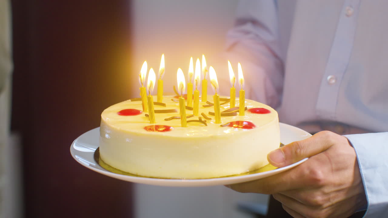 cerca de manos masculinas sosteniendo un trozo de tarta de cumpleaños en un plato