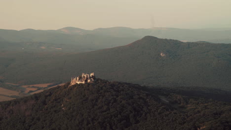 wide aerial shot of gymes castle ruins on green hill