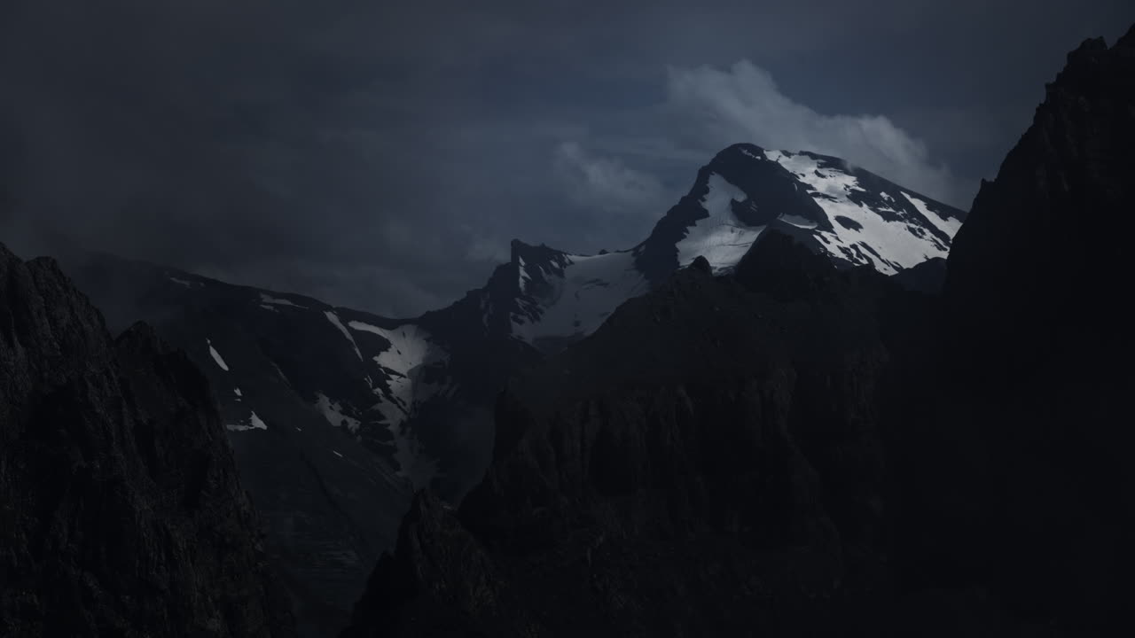 Picos de Montanha Escuros Sob Nuvens de Tempestade