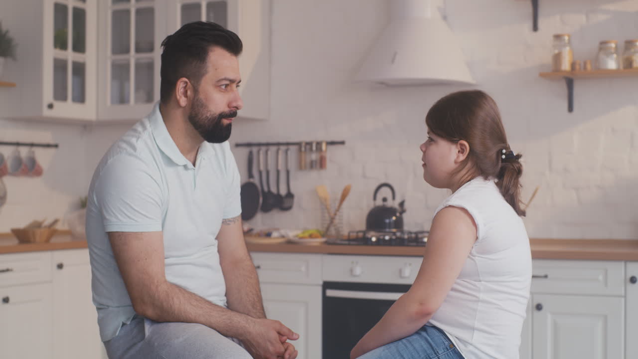 padre e hija hablando en la cocina