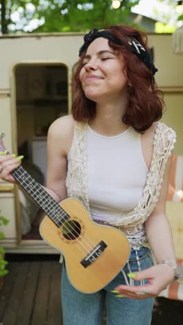 young woman playing ukulele outdoors