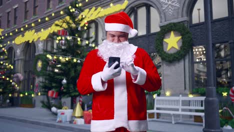 asian santa claus using smartphone while standing in christmas night