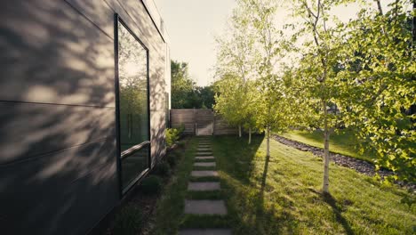 sunrise shot of a side path next to a luxury home leading to a wooden fence with a gate