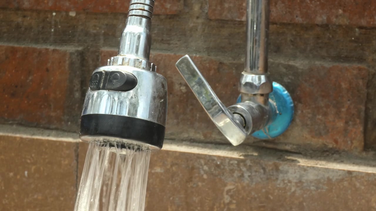 Aprire un rubinetto del lavandino. Una mano entra nell'inquadratura e gira la valvola, e l'acqua esce. La mano poi gira di nuovo la valvola e chiude il flusso d'acqua.