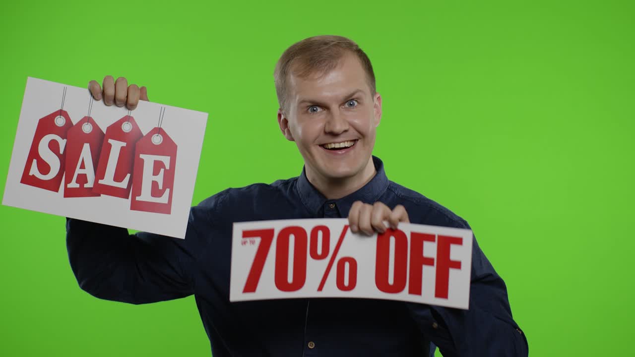 Uomo allegro che mostra la parola "Saldi" e la scritta "Fino al 70% di sconto". Concetto Black Friday.