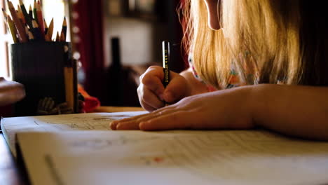 Young-girl-coloring-a-picture-with-pencils,-fine-motor-development