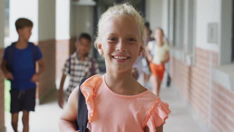 Video-of-happy-caucasian-girl-standing-at-school-corridor