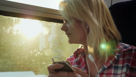 young woman on a train using a phone