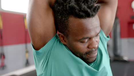 hombre afroamericano en forma estirándose en el gimnasio