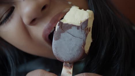 una chica disfrutando de un delicioso helado de vainilla cubierto de chocolate