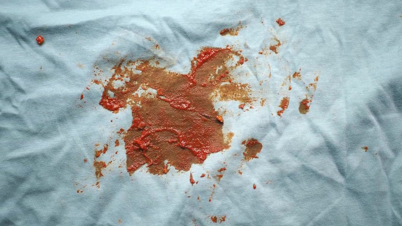 Messy Red Ketchup Stain on Light Blue Cloth