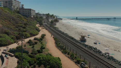 Vista-Aérea-De-La-Gente-Caminando-Por-El-Camino-De-La-Playa-En-La-Bifurcación-En-La-Carretera-Cerca-De-San-Clemente,-California