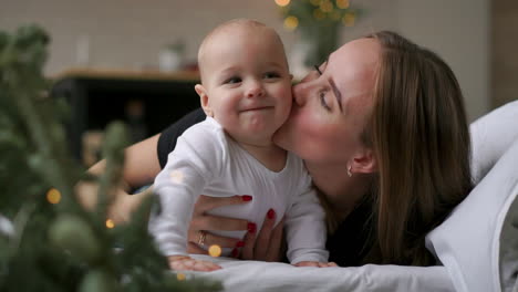 happy family. mother playing with her baby in the bedroom.