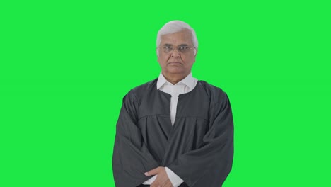 abogado senior indio serio mirando a la cámara pantalla verde