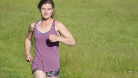 closeup of young woman running in a field at sunset