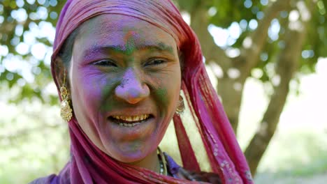 indian women close-up of face smeared with bright holi colors