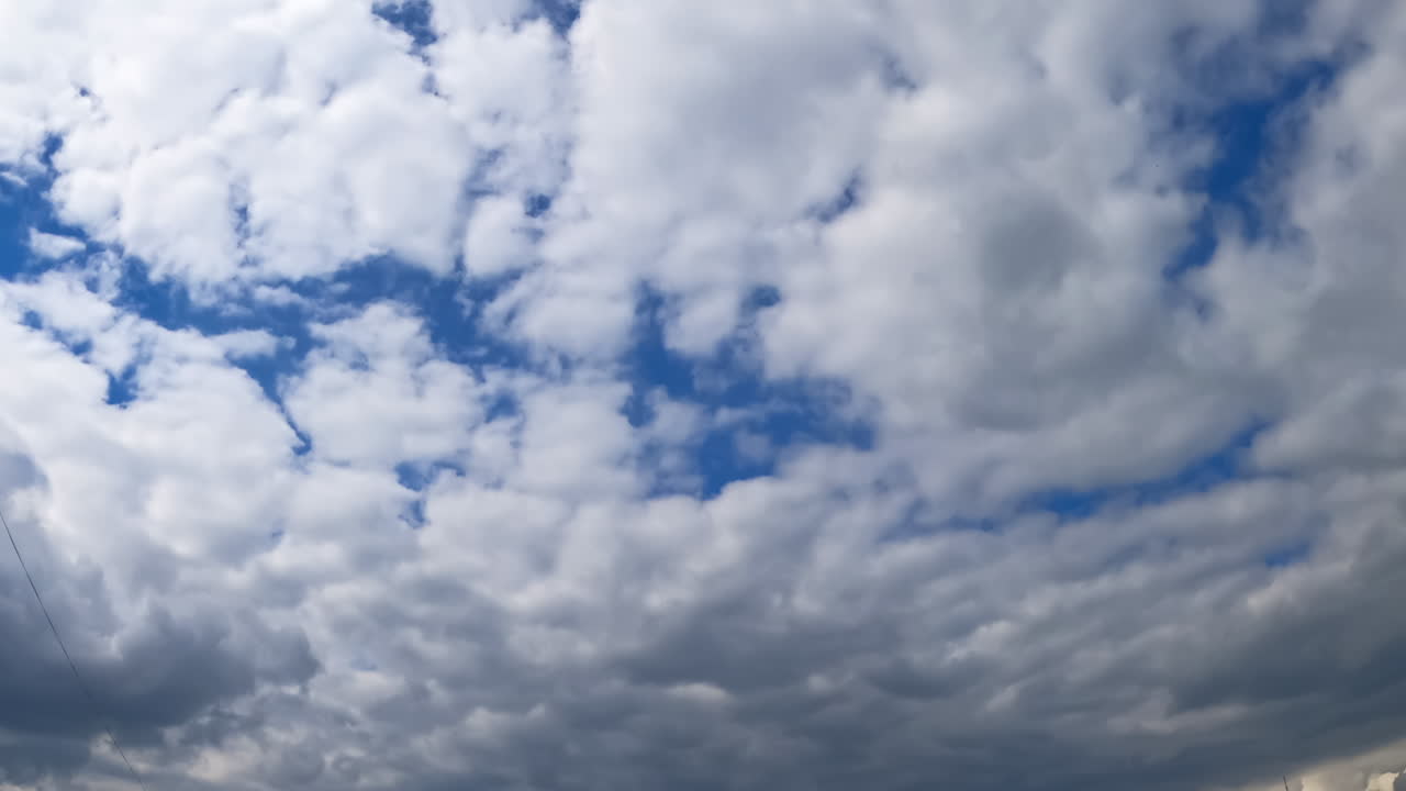 Grey dramatic cloudscape covering the skies. Rainy clouds gathering in the atmosphere. Low angle view. Timelapse.