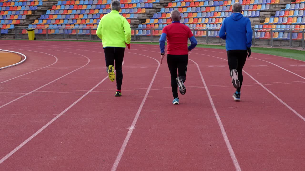 Gente corriendo en una pista en un estadio
